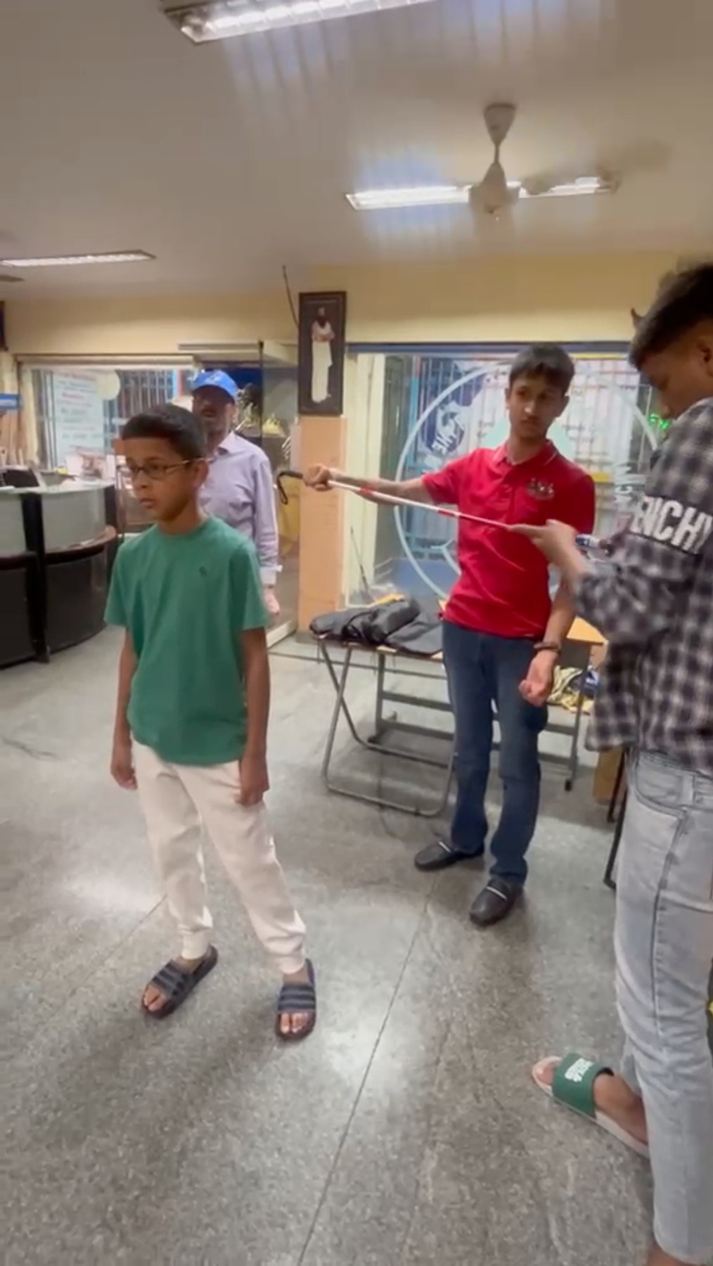 Vanij and Manan explaining a smart blind stick to students at the school